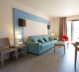 a living room with a blue couch and tables at Résidence Pierre & Vacances L'Archipel in Perros-Guirec