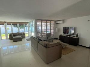 a living room with a couch and a television at CasaMar House Whit Pool 3 Bedrooms 3 Bathrooms in San Juan