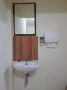 a bathroom with a white sink and a mirror at AG HOME STAY in Labuan Bajo