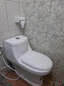 a bathroom with a white toilet in a room at AG HOME STAY in Labuan Bajo