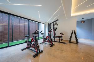 a gym with bikes and exercise equipment in a room at Kippal - Modern Oasis - ApartHotel in Cozumel