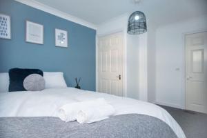 a bedroom with a white bed with blue walls at Spacious 1 Bed- Nunhead/Peckham-sleeps 4 in London