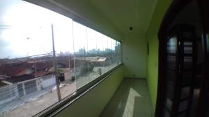 an empty room with a large window in a building at Hostel Canto da Ocian in Praia Grande