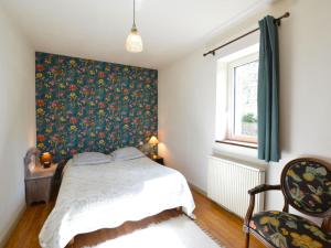 a bedroom with a bed and a floral wallpaper at Traditional holiday home with pool in Saint-Cernin-de-lʼHerm