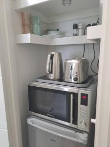 a microwave with pots and pans on top of it at Unwind in Woombye in Woombye