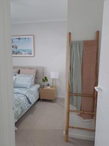 1 dormitorio con 1 cama y 1 mesa con lámpara en Unwind in Woombye, en Woombye