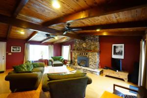 a living room with red walls and a stone fireplace at Black Oak Hill Vista near Yosemite - mountain views & starry night sky in Mariposa