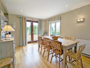 uma cozinha e sala de jantar com uma mesa de madeira e cadeiras em Long Meadow em Midhurst