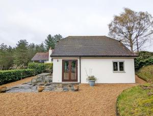 una casa blanca con un patio delante en Long Meadow, en Midhurst