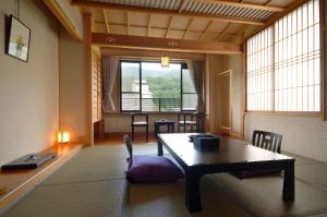 un soggiorno con tavolo e una grande finestra di Iwashimizu Ryori no Yado Kinosato a Zaō Onsen