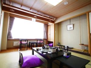 una sala da pranzo con tavolo e sedie imbottite viola di Iwashimizu Ryori no Yado Kinosato a Zaō Onsen