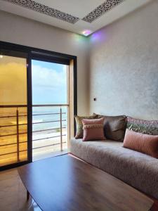 - un salon avec un canapé et une vue sur l'océan dans l'établissement clapotis, à El Jadida