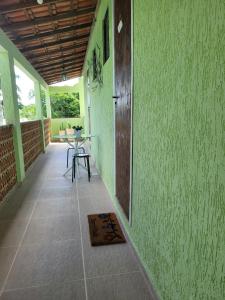 Habitación con mesa y pared verde. en ReCanto dos Passáros - Guaratiba, en Pedra de Guaratiba