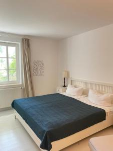 阿伦斯霍普Fe-Wo Schifferberg Lodge的卧室里有一张大床，上面铺着蓝色毯子