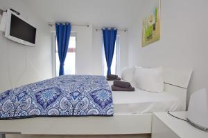 a bedroom with a bed with a blue and white comforter at Ostseetraum 04 - Aquamarin in Neuhaus
