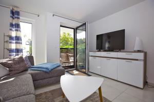 a living room with a couch and a flat screen tv at Ostseetraum 04 - Aquamarin in Neuhaus