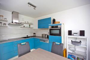 a blue kitchen with a table and blue cabinets at Ostseetraum 04 - Aquamarin in Neuhaus +3 photos