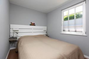 ヴストロにあるStrandnestの白いベッドルーム(ベッド1台、窓付)