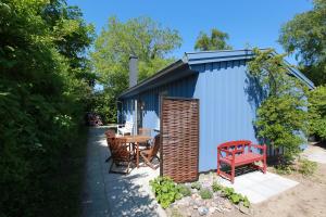 a blue shed with a red bench and a table at Strandnest in Wustrow
