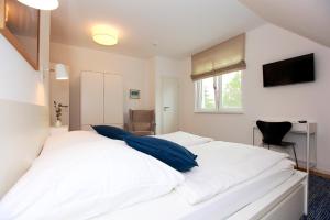 a bedroom with a large white bed with blue pillows at FeWo Bark Middenmang in Wustrow