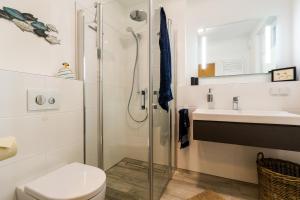 a bathroom with a shower and a toilet and a sink at Käptn Knaak in Wustrow +9 photos