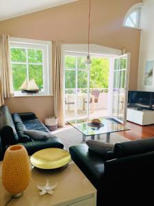 a living room with a couch and a glass table at Strandquartier 31 "Quartier 1" in Wustrow +6 photos