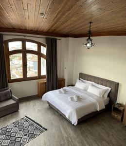 una camera da letto con un grande letto bianco e una finestra di Hotel Kroi near castle entrance castle and town view a Krujë (Kruja)