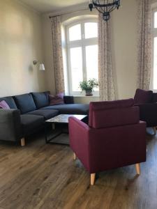 een woonkamer met een bank en 2 stoelen bij Villa Martha FW Erika in Wustrow