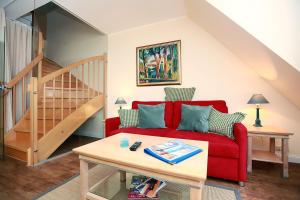 a living room with a red couch and a table at Haus Kranich App 426 in Neuhaus
