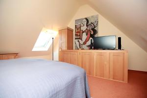 - une chambre avec un lit et une télévision sur une armoire dans l'établissement Haus Kranich App 426, à Neuhaus