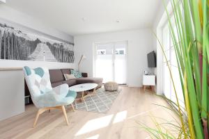 ein Wohnzimmer mit einem Sofa und einem Tisch in der Unterkunft Kleine Robbe Whg1 in Wustrow