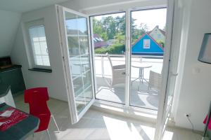 a living room with sliding glass doors and a patio at Haus Dünenrot OG-Whg DR-04 in Neuhaus
