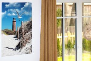 a picture of a lighthouse next to a window at Haus Eichkater in Dierhagen