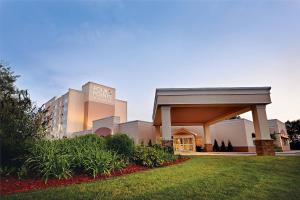 Four Points by Sheraton Kalamazoo في كالامازو: مبنى الفندق وامامه حديقة