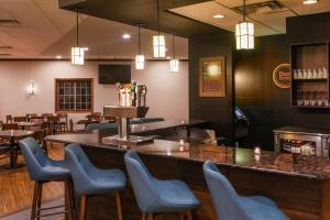 a bar in a restaurant with chairs and tables at Four Points by Sheraton Kalamazoo in Kalamazoo