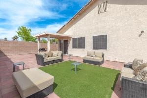 a patio with a lawn with couches and tables at Beautiful Spacious Single Story Vegas Home in Las Vegas