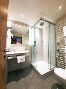 La salle de bains est pourvue d'une douche en verre et d'un lavabo. dans l'établissement Hotel Brunneck, à Schönau am Königssee