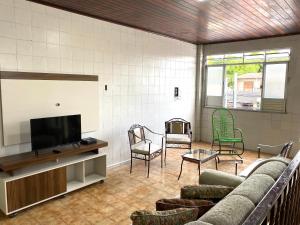 un soggiorno con divano, sedie e TV a schermo piatto di Casa no Centro, Home Office com ar condicionado ad Aracaju