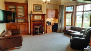 a living room with a couch and a fireplace at Greenfield Country Homestay in Pukeawa