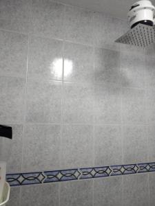 W łazience znajduje się prysznic wyłożony kafelkami z lampką. w obiekcie Habitaciones Centro Histórico w mieście Bogota