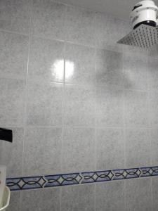a tiled shower with a light in a bathroom at centro histórico Habitaciones privadas in Bogotá