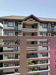a large apartment building with a pink balcony at StayPlus Metro Eclectic Glam 1BR in Manila