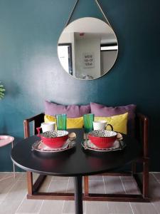 einen Tisch mit zwei Schüsseln und einem Spiegel in der Unterkunft StayPlus Metro Eclectic Glam 1BR in Manila