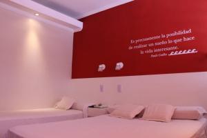 a bedroom with two beds and a red wall at Hotel Ychoalay Caz in Reconquista +40 photos
