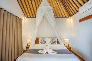 a bedroom with a bed with a canopy at Nusa Veranda Sunset Villas & Restaurant in Nusa Lembongan