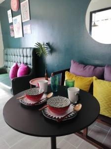einen Tisch mit Schalen und Tassen darüber in der Unterkunft StayPlus Metro Eclectic Glam 1BR in Manila