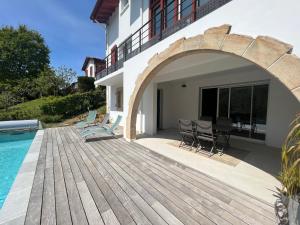 a house with a wooden deck next to a swimming pool at Appartement Ciboure, 3 pièces, 4 personnes - FR-1-239-927 in Ciboure