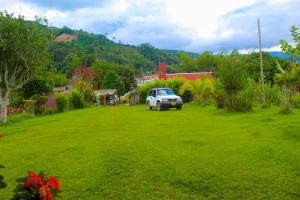 a white truck parked in a field of green grass at Hotel Casa de Teja in Norcasia