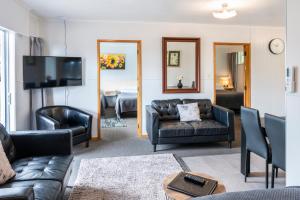 a living room with a couch and a tv at Dunrovin Motel in Taupo