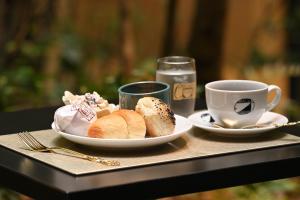 a table with a plate of bread and a cup of coffee at Prince Smart Inn Kyoto Sanjo in Kyoto